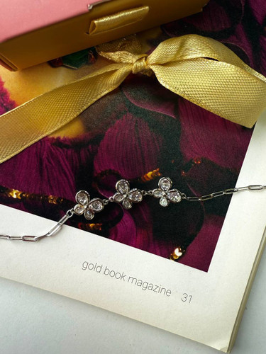 نمای نزدیک دستبند نقره زنانه طرح گل پروانهای داخل جعبه هدیه