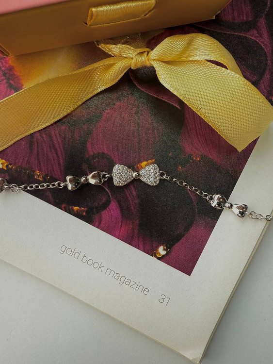 نمای نزدیک دستبند نقره طرح پاپیون داخل جعبه مخمل قرمز