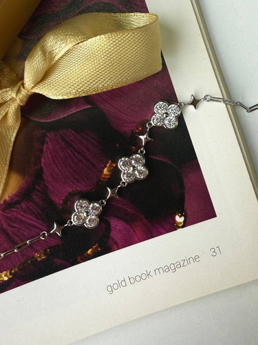 نمای نزدیک از دستبند نقره طرح گل مینیمال درون جعبه هدیه لوکس