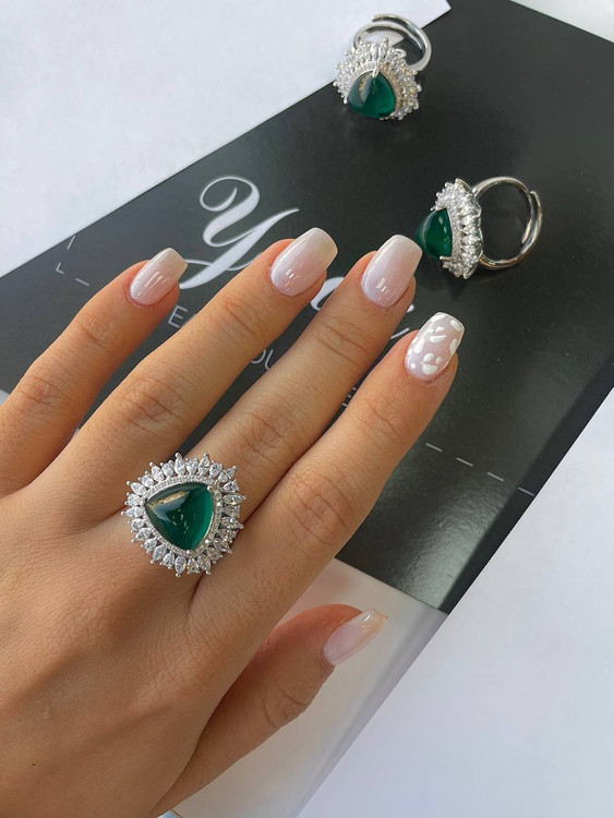 درخشش نگینهای زیرکونیوم پیرامون سنگ زمرد در انگشتر نقره اروند