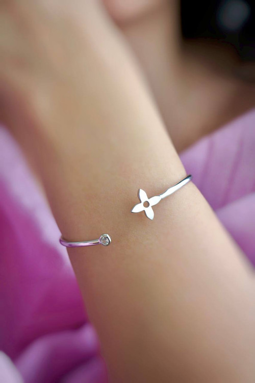 دستبند بنگل نقره طرح روبرتو کویین با گل چهارپر و تک نگین روی مچ دست